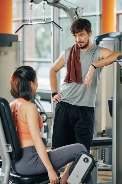 여자와 이야기를 나누며 운동하는 체육관에서 괴기에서 엉덩이 운동을 — 스톡 사진