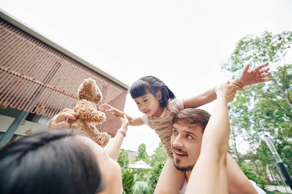 Pai Carregando Filha Sobre Sua Cabeça Mãe Dando Seu Urso — Fotografia de Stock