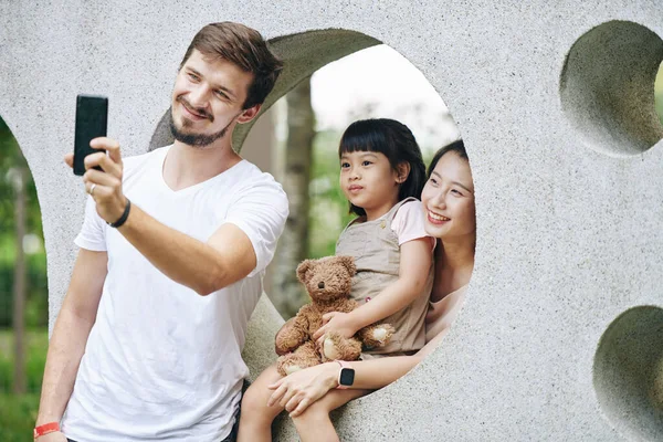 Küçük Melez Kız Anne Babasıyla Selfie Çektirmek Için Poz Veriyor — Stok fotoğraf