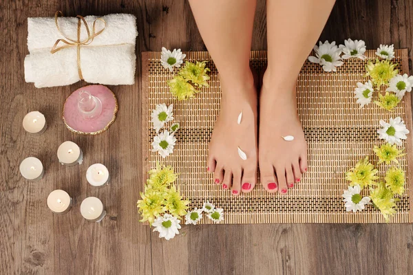 Pedicured Voeten Van Vrouw Servet Bloeiende Bloemen Brandende Kaarsen Rond — Stockfoto