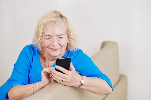 Gülümseyen Yaşlı Kadın Akıllı Telefonundaki Mesajları Bildirileri Kontrol Ediyor — Stok fotoğraf