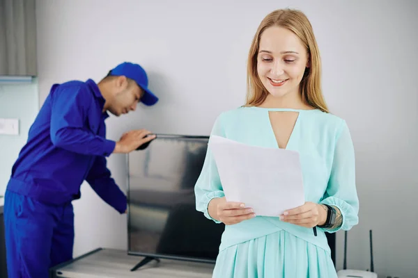 Muito Sorrindo Jovem Mulher Ler Contrato Quando Handyman Instalar Set — Fotografia de Stock