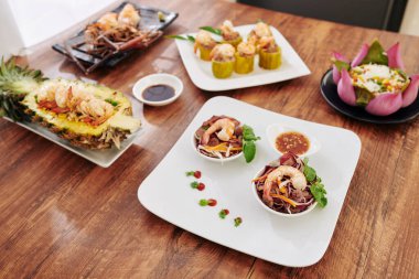 Akşam yemeği için çeşitli Asya yemekleri: salata, sebzeli kızarmış pirinç, kabak dolması ve dikenli ıstakoz.