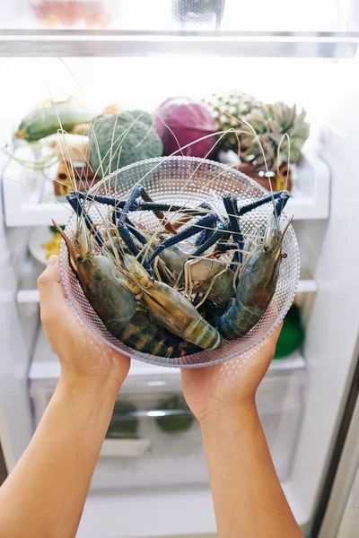 Händer Kvinna Sätta Glas Skål Med Blå Taggiga Hummer Kylskåp — Stockfoto