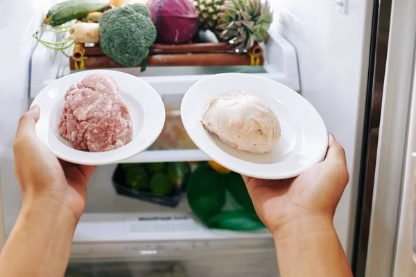 Frau Stellt Teller Mit Schweinefleisch Und Hühnchen Kühlschrank — Stockfoto