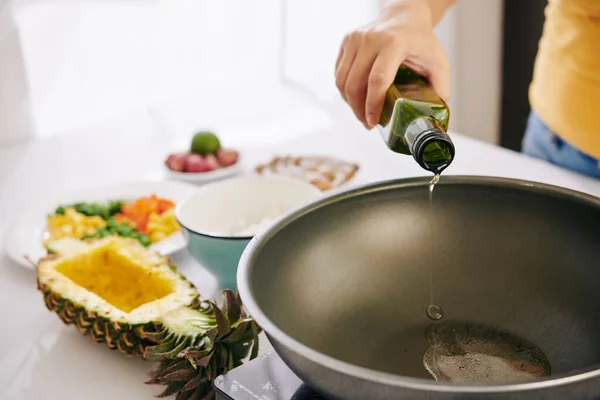 野菜とご飯を炒め 伝統料理を作るためにフライパンに野菜油を注ぐ女性 — ストック写真