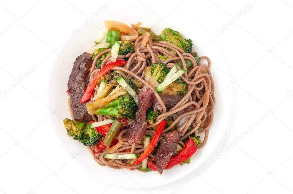 Buckwheat noodles with beef, onions, green beans, paprika, broccoli, tyriaki sauce, cucumber. On a white plate. View from above. White background. Isolate