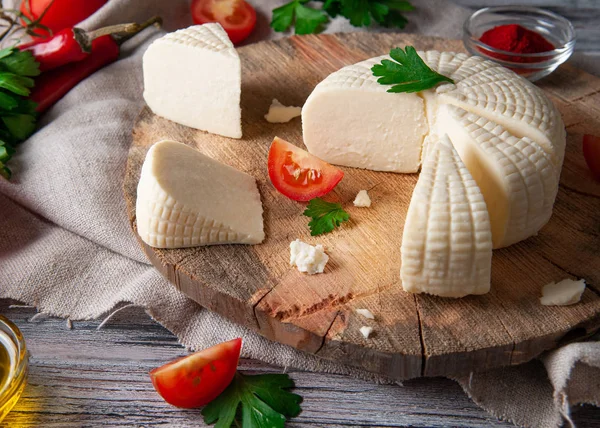 Sýr Suluguni Krájí Velké Kusy Dřevěné Kulaté Desce Zdobené Petrželovými — Stock fotografie