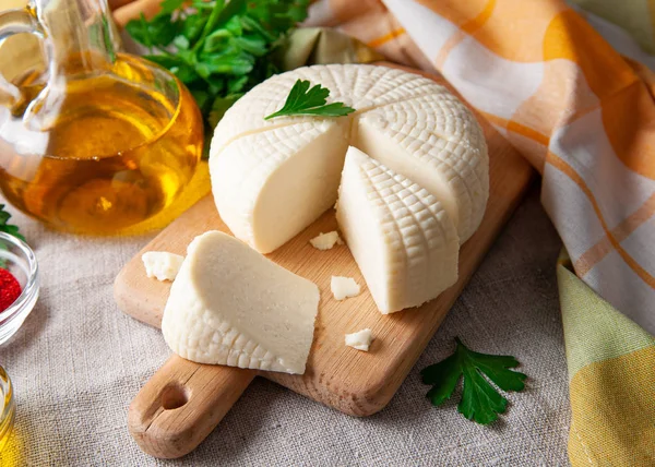 Sýr Suluguni Krájí Velké Kusy Dřevěné Desce Ozdobená Petrželovými Listy — Stock fotografie