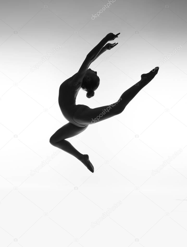 Girl in a jump. Woman silhouette. Black and white photo.