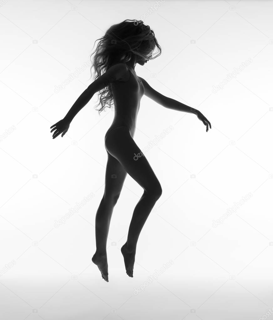 Girl with long hair jumping. Woman silhouette.