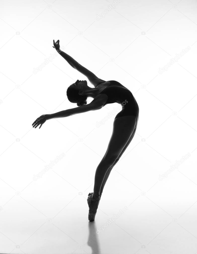 Ballerina posing black leotard and pointe shoes