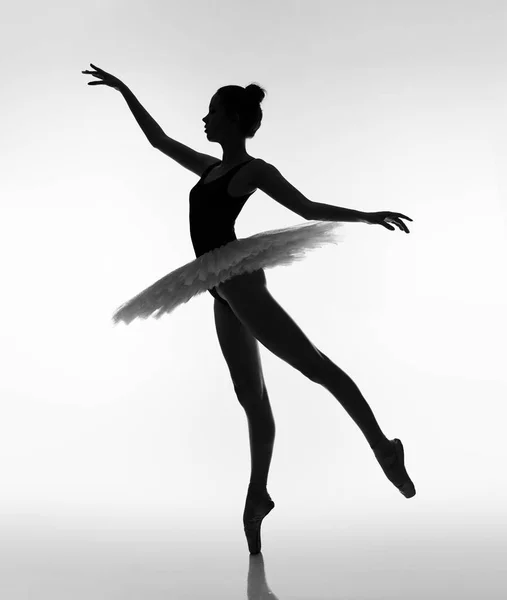 Girl dancing in ballet tutu and pointe shoes. Black and white photo.