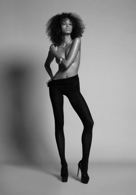 Siyah tayt ve topuklularla poz veren Afrikalı kız