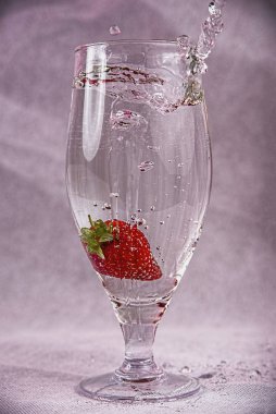 fresh strawberries in water with splashes and bubbles