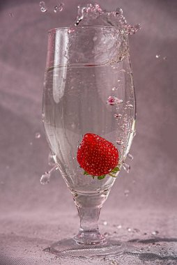 fresh strawberries in water with splashes and bubbles