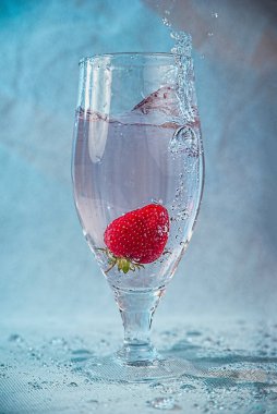 fresh strawberries in water with splashes and bubbles