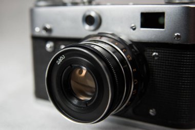 Beyaz zemin üzerinde lens olan eski kamera
