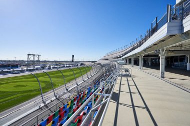 Daytona International Speedway, tribünler oturma alanında bir platform. Güneşli bir gün mavi gökyüzü ile Çimen yeşildir ve oturma boştur.