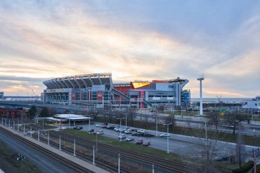 Cleveland, Ohio/Amerika Birleşik Devletleri - 5th Mart 2018: Downtown Cleveland gün batımı arka plan ve ön plan bir hızlı tren istasyonu ile ve bir park yeri parçalarıyla ilk enerji Stadyumu. 
