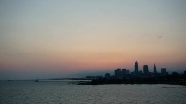 Cleveland Ohio 'da renkli bir sabah ve şehir merkezinde güneş doğuyor. Erie Gölü pürüzsüzdür. Gökyüzünde birkaç bulut vardır. Mavi, sarı ve pembe renklidir. Şehir gün doğarken uyanıyor..