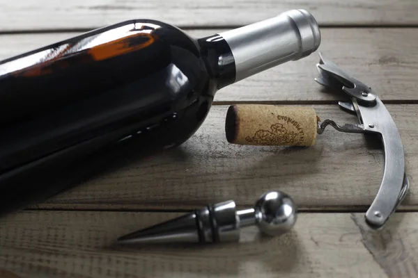 wine bottle, bottle cap and corkscrew with cork