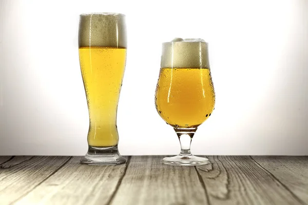 Довгий келих і келих пива з піною — стокове фото