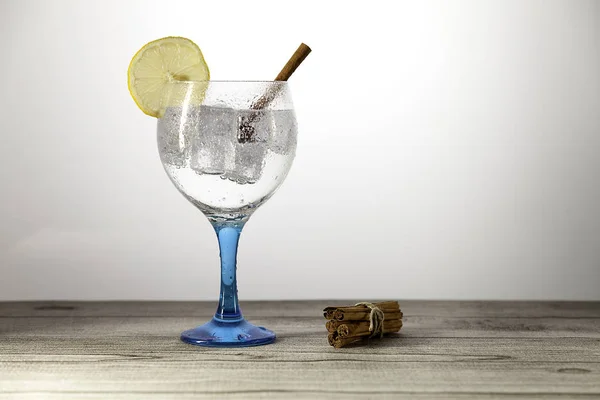 Джин тоник на синем стекле с ломтиком лимона — стоковое фото