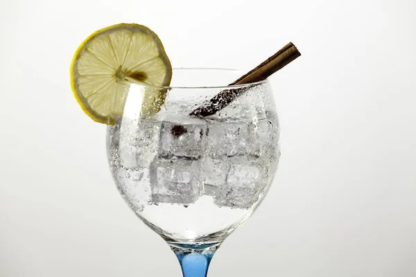 Detalj gin tonic på blått glas med citron och kanel pinnar — Stockfoto