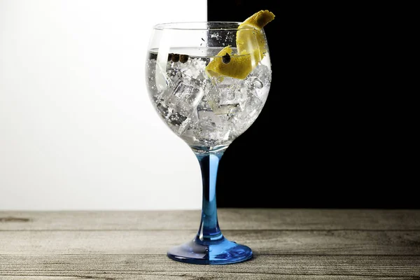 Gin tonic su vetro blu con limone e grani di pepe — Foto Stock