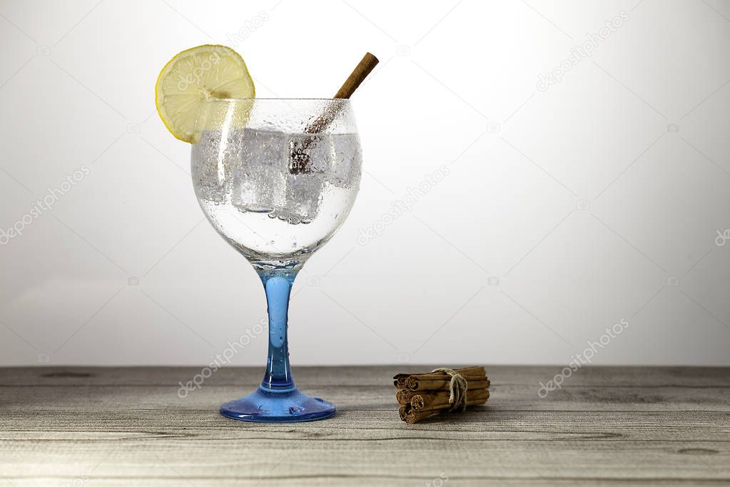 gin tonic on blue glass with  lemon slice