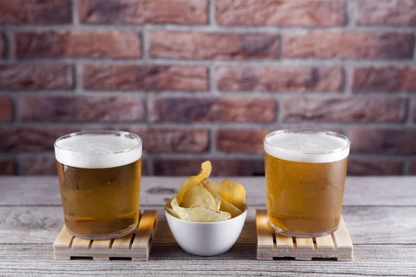 Дві склянки пива на піддоні з чіпсами — стокове фото