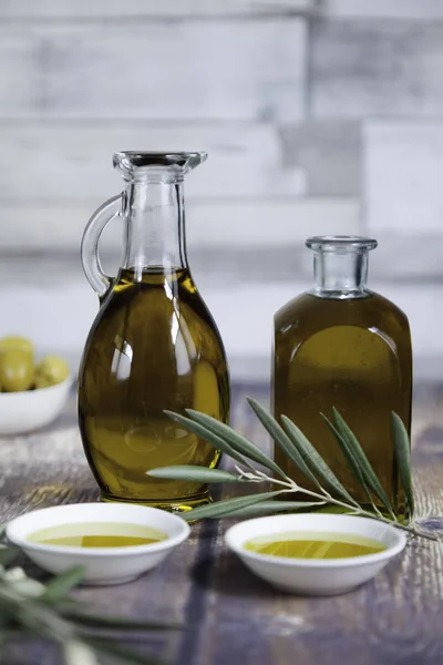 Dos botellas de aceite y hojas de olivo de cerca — Foto de Stock