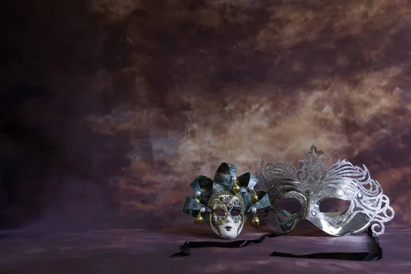 Srebrny i weneckie maski karnawałowe na brązowej fantazji — Zdjęcie stockowe