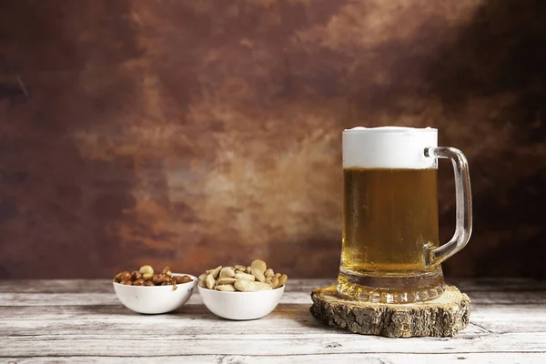 Tazza di birra con arachidi e mandorle — Foto Stock