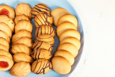 Yukarıdan beyaz bir masanın arka planında mavi bir tabakta çeşitli çaydanlıklar. en üstteki görünüm