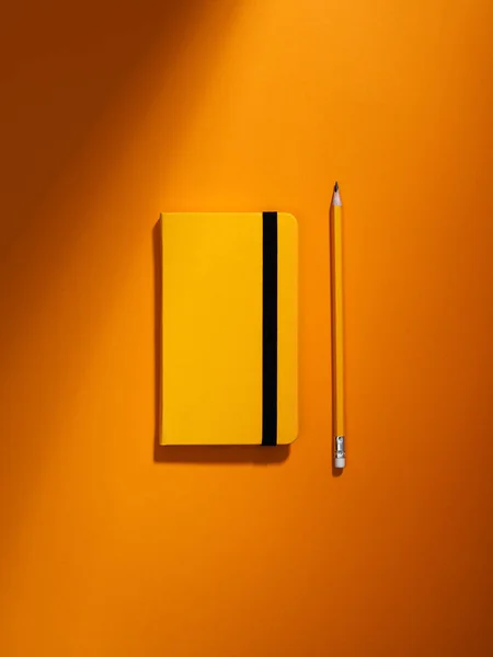 Cuaderno naranja y lápiz . —  Fotos de Stock