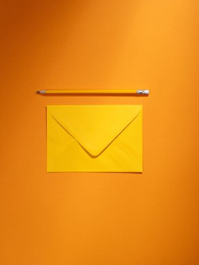 Turuncu zarf ve kalem.