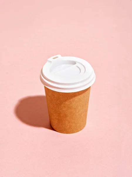 Copo de café descartável no fundo rosa . — Fotografia de Stock