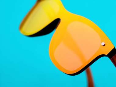 Mavi arkaplanda minimal güneş gözlüğü.