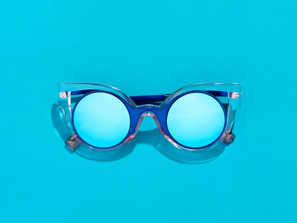 Eine einzige blaue Sonnenbrille auf pastellfarbenem Hintergrund. — Stockfoto