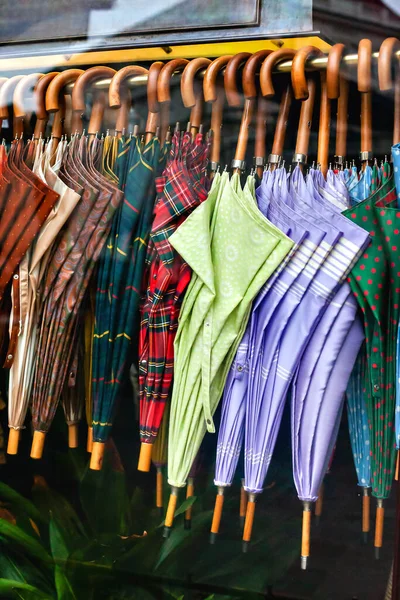 Fila de coloridos paraguas con asas de madera . — Foto de Stock