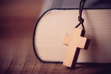 Yakın çekim vurdu haç ve İncil'in eski ahşap masa üzerine