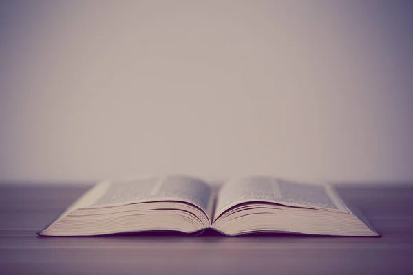 An opened holy bible on a wooden table