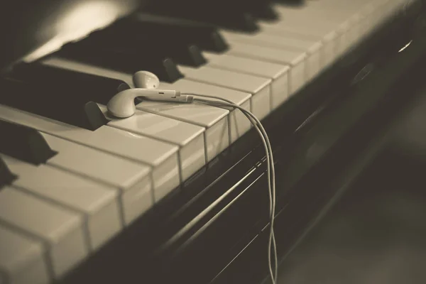 Auscultadores no teclado do piano — Fotografia de Stock