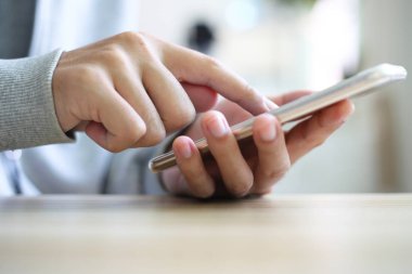 Adam akıllı telefon masada oynarken
