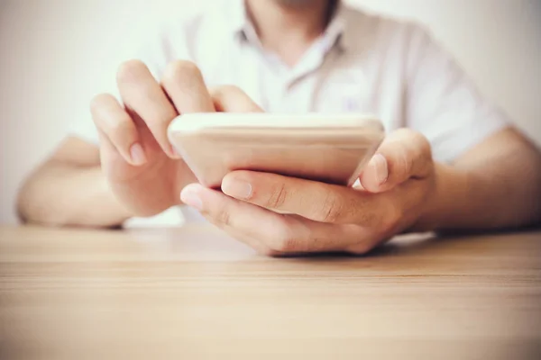 Adam akıllı telefon masada oynarken