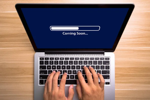 Konsept dizüstü bilgisayar ekran ile yazarak eller üzerinde klavye coming soon