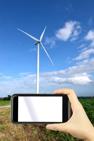 hand shoting by smart phone with background wind turbines windmi