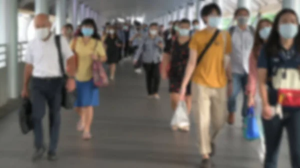 Blured defocused. The crowd is wearing protective masks prevent Coronavirus, Covid 19 virus during virus outbreak and PM2.5 air pollution crisis rush hour Bangkok, Thailand.